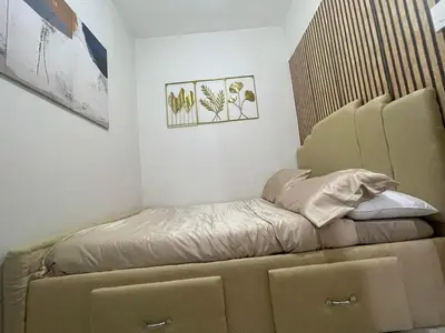 a bed sitting in a corner of a room at Field Residences Condo Hotel in Manila