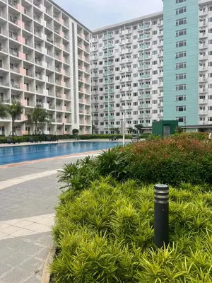 a large apartment complex with a swimming pool and buildings at Field Residences Condo Hotel in Manila