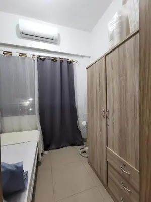 a small bathroom with a bed and a shower at Shore 2 Residences in Manila