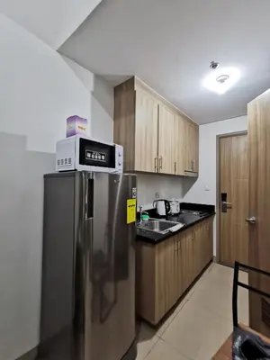 a kitchen with a stainless steel refrigerator with a microwave at Shore 2 Residences in Manila