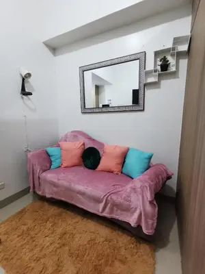 a purple couch in a living room with a mirror at Shore 2 Residences in Manila