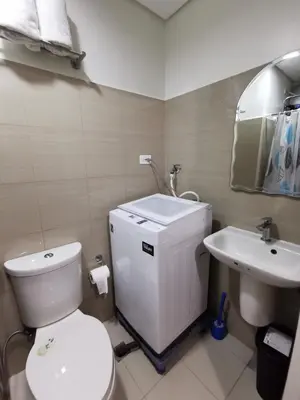 a bathroom with a white toilet and a sink at Shore 2 Residences in Manila