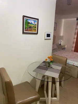 a room with a table and chairs and a bed at Happy stay Condotel near NAIA terminal 3 in Manila