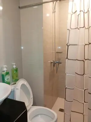 a bathroom with a shower with a toilet and a sink at Happy stay Condotel near NAIA terminal 3 in Manila