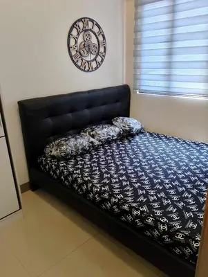 a bed in a room with a clock on the wall at 1BR with balcony Condotel in MOA Complex, Entertainment City, near NAIA, free wifi, netflix in Manila
