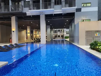 a large swimming pool with chairs in a building at 1BR with balcony Condotel in MOA Complex, Entertainment City, near NAIA, free wifi, netflix in Manila