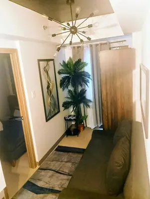 a living room with a couch and a ceiling fan at 1BR with balcony Condotel in MOA Complex, Entertainment City, near NAIA, free wifi, netflix in Manila
