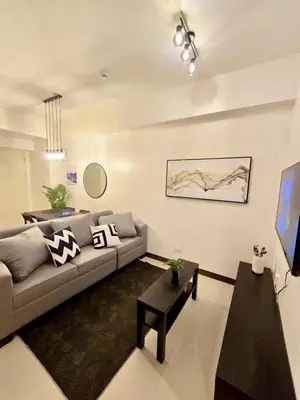 a living room with a couch and a tv at SG Urban Staycation in Manila