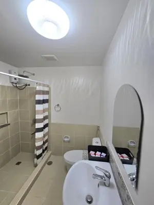 a white bathroom with a sink and a mirror at SG Urban Staycation in Manila