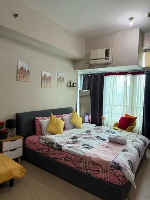 a bedroom with a bed with yellow and pink pillows at Relaxing shining sunrise in Manila