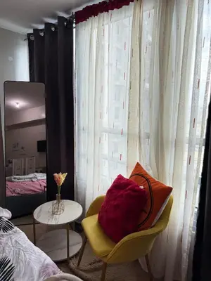 a bedroom with a bed and a chair and a mirror at Relaxing shining sunrise in Manila