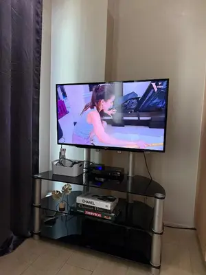 a flat screen tv sitting on a black stand at Relaxing shining sunrise in Manila