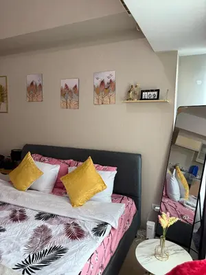 a bedroom with a bed with yellow and pink pillows at Relaxing shining sunrise in Manila