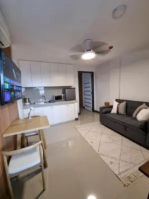 a living room with a couch and a kitchen at Flat 35, Unit 3C in Manila