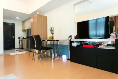 a living room with a table and a flat screen tv at Avant Apartments at The Fort in Manila