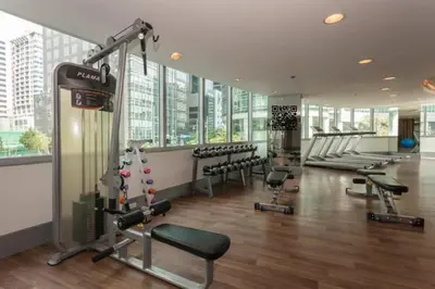 a gym with treadmills and machines in a building at Avant Apartments at The Fort in Manila