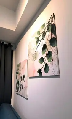 two paintings on a wall in a room at El Marhabea Crib in Manila