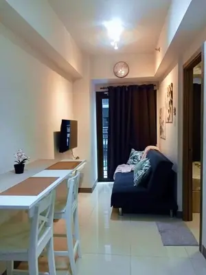a living room with a table and a couch at El Marhabea Crib in Manila