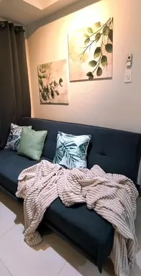 a blue couch with pillows and a blanket on it at El Marhabea Crib in Manila