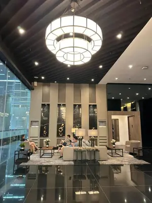 a lobby with people sitting on couches in a building at 1BR Air Residences condo, Ayala Ave, Makati in Manila