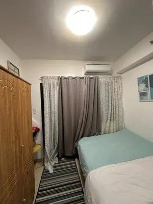 a bedroom with two beds and a window with a dresser at 1BR Ayala Makati Apartment at Lush Residences in Manila