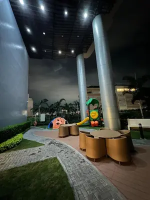 a park with a playground with benches and a slide at 1BR Ayala Makati Apartment at Lush Residences in Manila