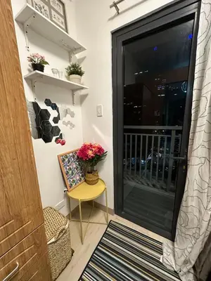 a door to a balcony with a vase of flowers at 1BR Ayala Makati Apartment at Lush Residences in Manila