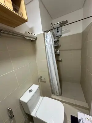 a small bathroom with a toilet and a shower at 1BR Ayala Makati Apartment at Lush Residences in Manila