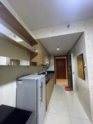 a kitchen with a stainless steel refrigerator and wooden cabinets at 10hrs stay in Manila