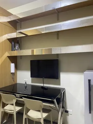 a dining room table with chairs and a flat screen tv at 10hrs stay in Manila