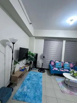 a living room with a blue couch and a blue rug at Phebestaycation in Manila