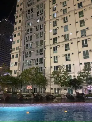 a large building with a swimming pool in front of it at Phebestaycation in Manila