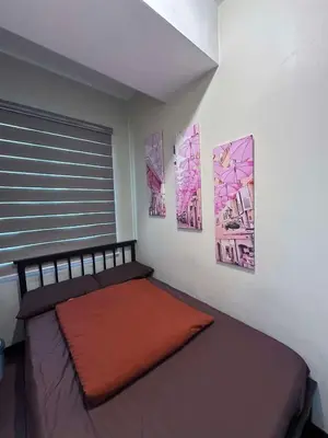 a bed in a room with pictures on the wall at Phebestaycation in Manila