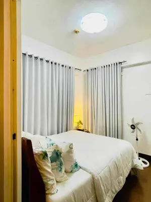 a bedroom with a white bed with white curtains at Casa Broganza in Manila