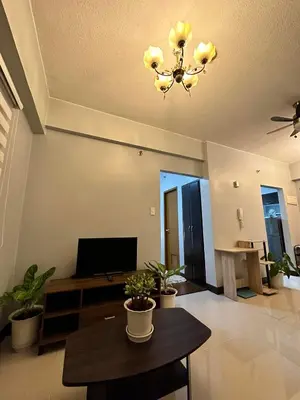 a living room with a table and a chandelier at Casa Broganza in Manila