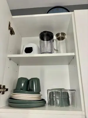 a white cabinet with plates and utensils at Casa Valentine - Azure Urban Resorts Residences in Manila