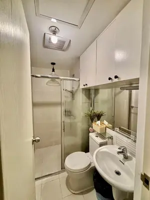 a bathroom with a shower and a toilet and a sink at Casa Valentine - Azure Urban Resorts Residences in Manila