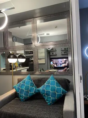 a living room with a couch and a mirror at Casa Valentine - Azure Urban Resorts Residences in Manila