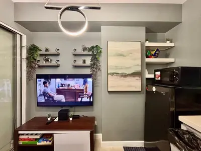 a living room with a flat screen tv on a wall at Casa Valentine - Azure Urban Resorts Residences in Manila