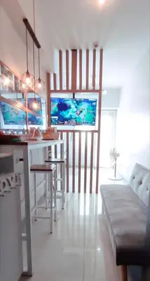 a kitchen with a bar with chairs and a table at Coast Residences Pasay City 1 bedroom in Manila