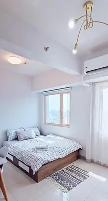 a bedroom with a bed in a room with a window at Coast Residences Pasay City 1 bedroom in Manila