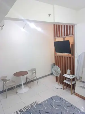 a living room with a table and chairs and a tv at Coast Residences Pasay City 1 bedroom in Manila