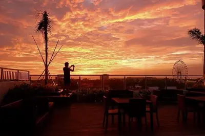 a man taking a picture of the sunset at Coast Residences Pasay City 1 bedroom in Manila