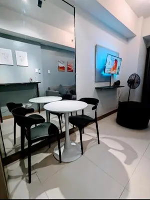 a room with two tables and chairs and a television at Mall of Asia Condo Pasay in Manila