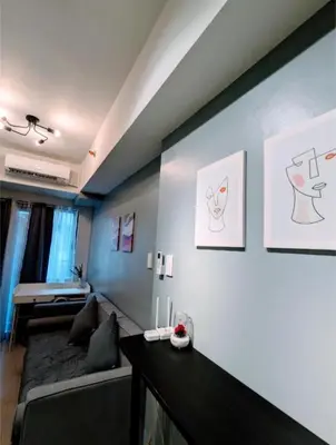 a living room with a couch and drawings on the wall at Mall of Asia Condo Pasay in Manila