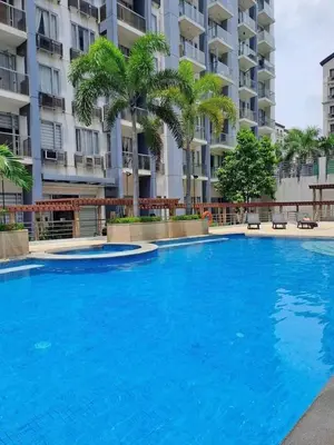 a large blue swimming pool in front of a building at One Palm Tree Villas Near NAIA terminal 3 in Manila
