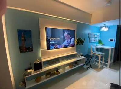 a living room with a flat screen tv on a wall at One Palm Tree Villas Near NAIA terminal 3 in Manila