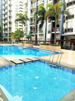 a large blue swimming pool in front of a building at One Palm Tree Villas Near NAIA terminal 3 in Manila