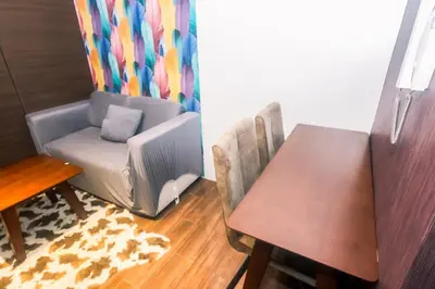 a dining room with a table and a chair and a computer at Air residence Snuggle in Style 1 BR condo Makati swim gym park surf 300 Mb in Manila