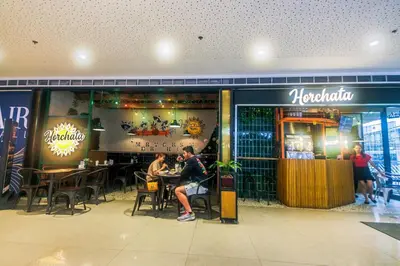 a group of people sitting at tables in a restaurant at Air residence Snuggle in Style 1 BR condo Makati swim gym park surf 300 Mb in Manila